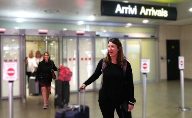 Professional chauffeur holding welcome sign at airport