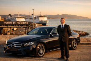 Chauffeur beside a luxury Mercedes van at the Port of Piombino for private transfer service.